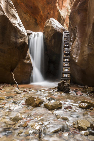 Long exposure at waterfall and ladder in Kanarra Creek Canyon. Kanarraville, Iron County, Utah, USA.