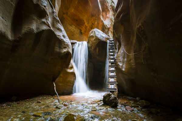 Long exposure at waterfall and ladder in Kanarra Creek Canyon. Kanarraville, Iron County, Utah, USA.