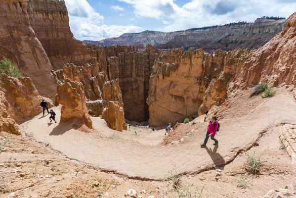 Hikers on Wall Street section of Navajo Loop Trail. Bryce Canyon National Park, Garfield County, Utah, USA.