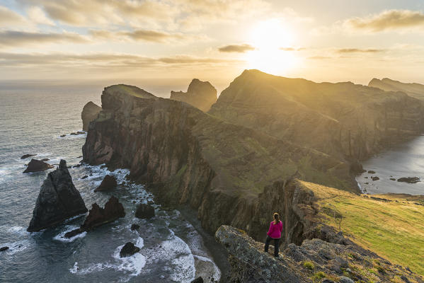 Woman admiring the view of Point of St Lawrence and Furado Point at dawn. Canical, Machico district, Madeira region, Portugal. (MR)