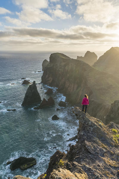 Woman admiring the view of  Point of St Lawrence and Furado Point. Canical, Machico district, Madeira region, Portugal.