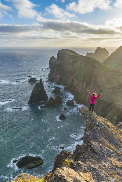 Woman admiring the view of  Point of St Lawrence and Furado Point. Canical, Machico district, Madeira region, Portugal.