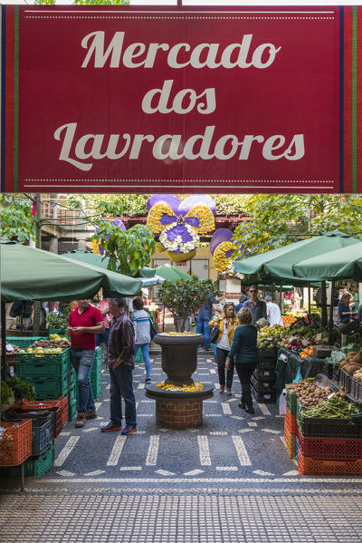 Customers under the sign at the entrance of Mercado dos Lavradores - Farmers' Market. Funchal, Madeira region, Portugal.