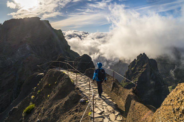 Hiker walking on Vereda do Areeiro, the trail that links Pico Ruivo to Pico do Arieiro and its observatory. Funchal, Madeira region, Portugal. (MR)