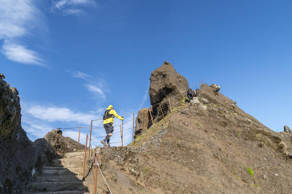 Hiker climbing up the steps on Vereda do Areeiro, the trail that links Pico Ruivo to Pico do Arieiro, Funchal, Madeira region, Portugal.