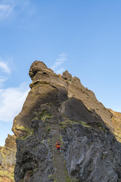 Hiker climbing up the steps on Vereda do Areeiro, the trail that links Pico Ruivo to Pico do Arieiro, Funchal, Madeira region, Portugal.