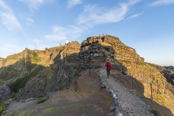 Hiker walking on the trail to Pico do Ariero Observatory. Pico do Arieiro, Funchal, Madeira region, Portugal.