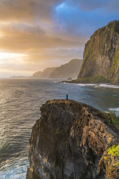 Person on a cliff watching the sunrise. Faial, Santana municipality, Madeira region, Portugal. (MR)