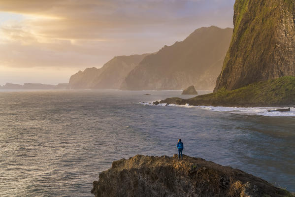 Woman on a cliff watching the sunrise. Faial, Santana municipality, Madeira region, Portugal. (MR)