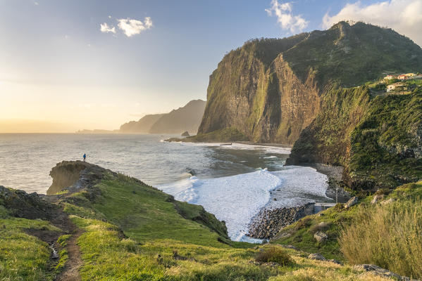 Man overlooking the village of Faial and its beach and cliffs. Faial, Santana municipality, Madeira region, Portugal.