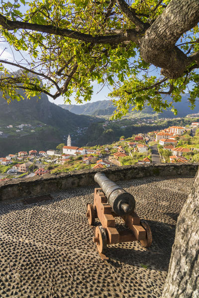 Historical cannon at Faial fortress with the village in the background. Faial, Santana municipality, Madeira region, Portugal.