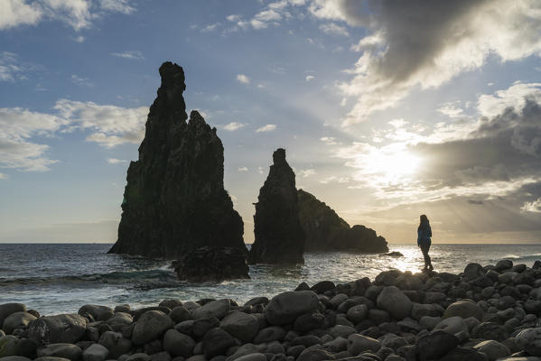 Woman admiring Rib and Janela islets. Porto Moniz, Madeira region, Portugal.