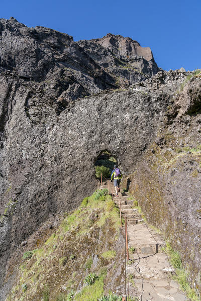 Man climbing up the steps on the trail from Pico Ruivo to Pico do Areeiro. Funchal, Madeira region, Portugal.