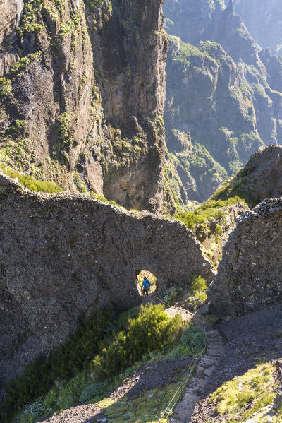 Hiker descenging the steps on the trail from Pico Ruivo to Pico do Areeiro. Funchal, Madeira region, Portugal.