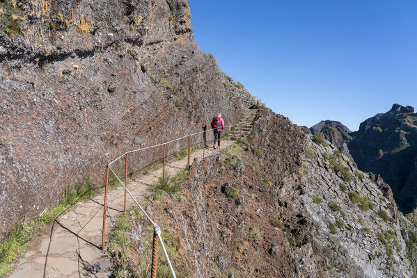 Hiker walking on the trail from Pico Ruivo to Pico do Areeiro. Funchal, Madeira region, Portugal.