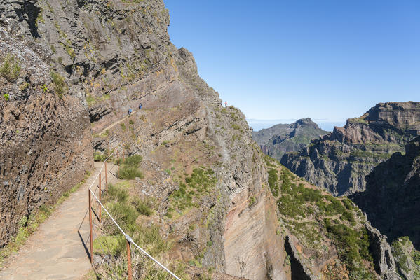 Hikers walking on the trail from Pico Ruivo to Pico do Areeiro. Funchal, Madeira region, Portugal.