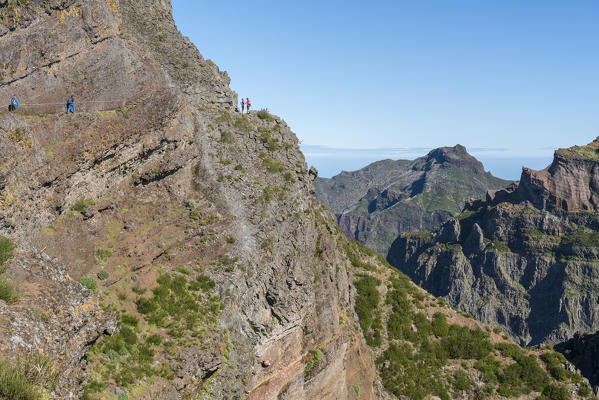 Hikers walking on the trail from Pico Ruivo to Pico do Areeiro. Funchal, Madeira region, Portugal.