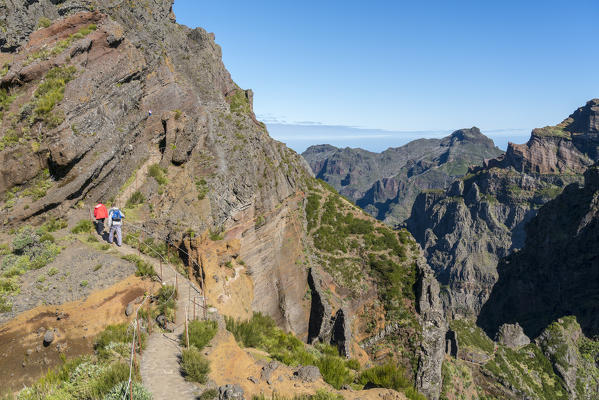 Two hikers walking on the trail from Pico Ruivo to Pico do Areeiro. Funchal, Madeira region, Portugal.