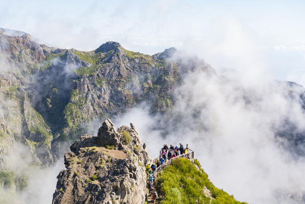 People admiring the landscape from Nino da Manta viewpoint, on the trail from Pico Ruivo to Pico do Areeiro. Funchal, Madeira region, Portugal.