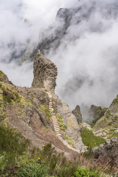 Person climbing up the steps on the trail at Pico do Areeiro. Funchal, Madeira region, Portugal.