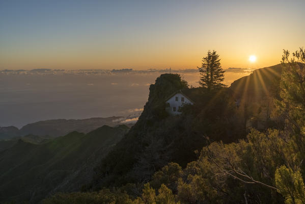 Sunrise behind Casa do Obrigo hut from the trail to Pico Ruivo. Achada do Teixeira, Santana municipality, Madeira region, Portugal.