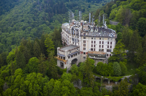 Aerial view of the abandoned Grand Hotel Campo dei Fiori in spring. Campo dei Fiori, Varese, Parco Campo dei Fiori, Lombardy, Italy.