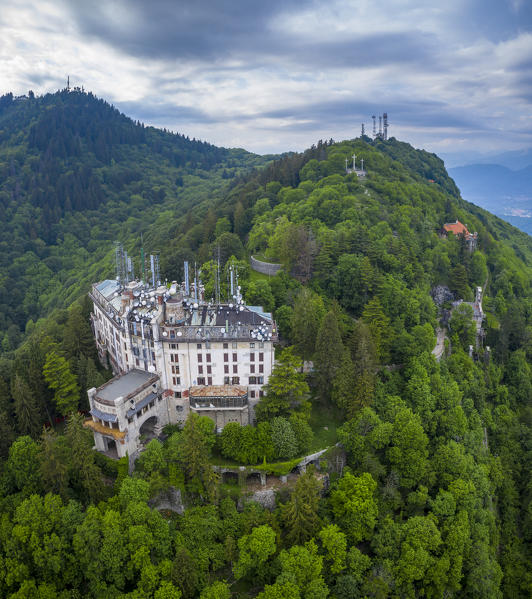 Aerial view of the abandoned Grand Hotel Campo dei Fiori in spring. Campo dei Fiori, Varese, Parco Campo dei Fiori, Lombardy, Italy.