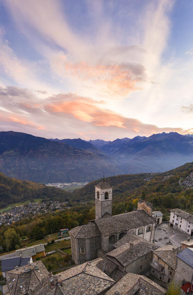 Panoramic of church and village of Caspano at sunset, Costiera dei Cech, Sondrio province, lower Valtellina, Lombardy, Italy