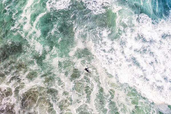 Elevated view of surfer paddling into the waves, Unstad, Vestvagoy, Lofoten Islands, Norway