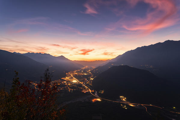 Fiery sky at sunset over towns and mountains of lower Valtellina, Campo Tartano, Val Tartano, Sondrio province, Lombardy, Italy