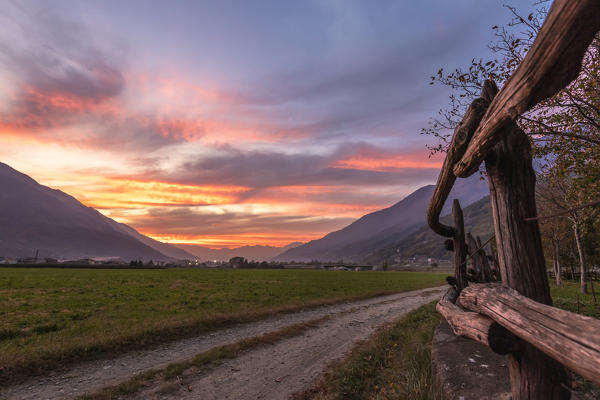 Colorful sky at sunset over the rural landscape surrounding Cosio Valtellino, Valtellina, Sondrio province, Lombardy, Italy