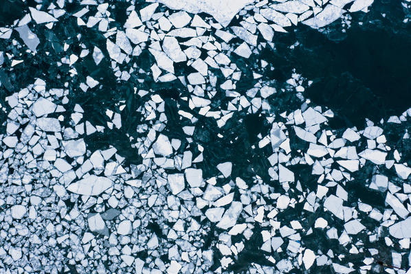 Aerial view of ice sheets in the frozen sea next to harbor, Ballstad, Vestvagoy, Lofoten Islands, Norway