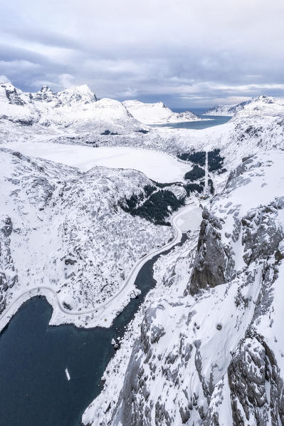 Aerial panoramic of fjord from Flakstadoya towards lake Storvatnet covered with snow, Nusfjord, Lofoten Islands, Norway