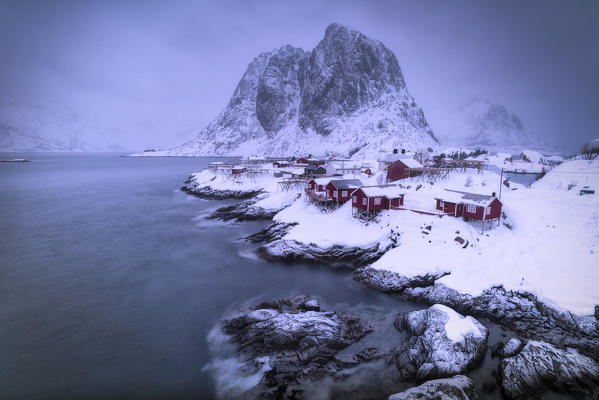 Dusk over the icy sea surrounding the fishing village of Hamnoy covered with snow, Nordland, Lofoten Islands, Norway