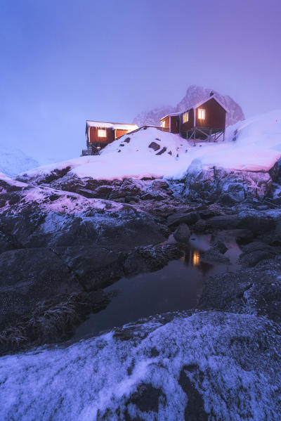 Dusk over traditional fishermen huts covered with snow, Hamnoy, Nordland, Lofoten Islands, Norway