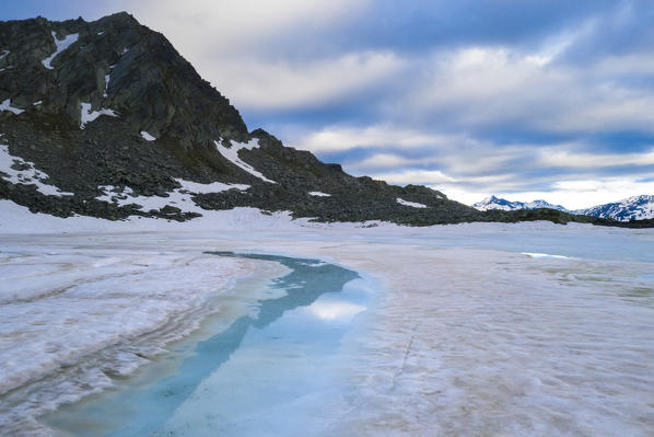 Ice melting at Lago Nero during spring thaw, Montespluga, Valchiavenna, Valle Spluga, Valtellina, Sondrio, Lombardy, Italy