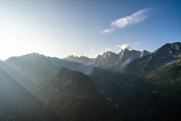 Piz Badile and Cengalo lit by sun rays at dawn, Soglio, Val Bregaglia, canton of Graubunden, Switzerland