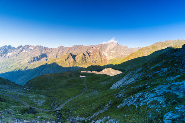 Cima di Pietra Rossa and Lago Nero lit by sunrise, Gavia Pass, Valfurva, Valtellina, Sondrio province, Lombardy, Italy