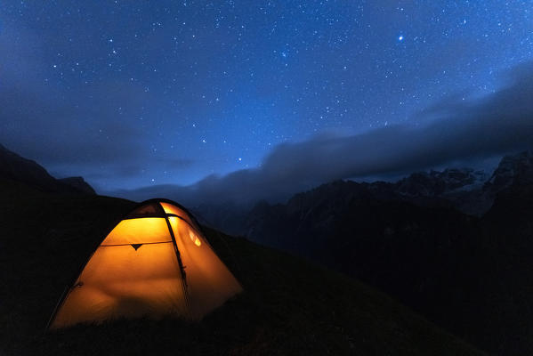 Illuminated tent under the starry sky, Tombal, Soglio, Val Bregaglia, canton of Graubunden, Switzerland