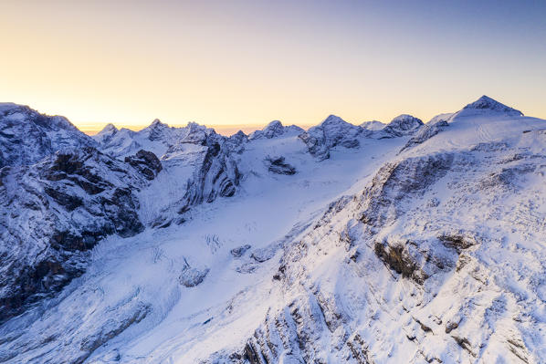 Pink sunrise over  the snowy Madaccio, Cima Tuckett and Monte Livrio, Stelvio Pass, Sondrio province, Valtellina, Lombardy, Italy