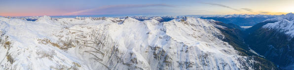 Aerial panoramic of the Stelvio Pass road covered with snow at dawn, Bolzano province, South Tyrol side, Italy