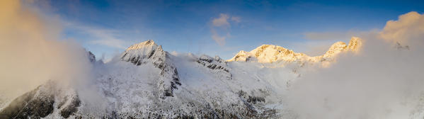 Aerial panoramic of Monte Disgrazia and Corni Bruciati covered by mist at sunset, Val Masino, Valtellina, Sondrio, Lombardy, Italy