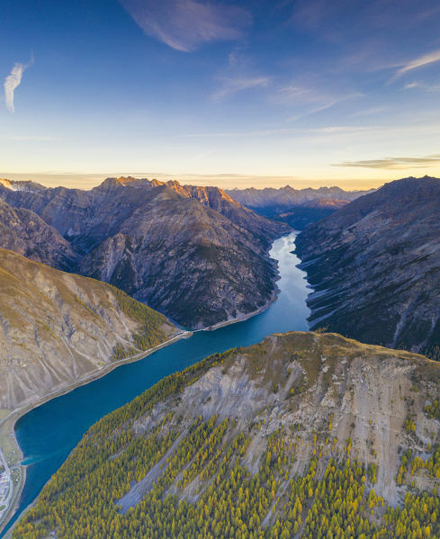 Sunrise over woods above lake of Livigno in autumn, aerial view, Sondrio province, Valtellina, Lombardy, Italy