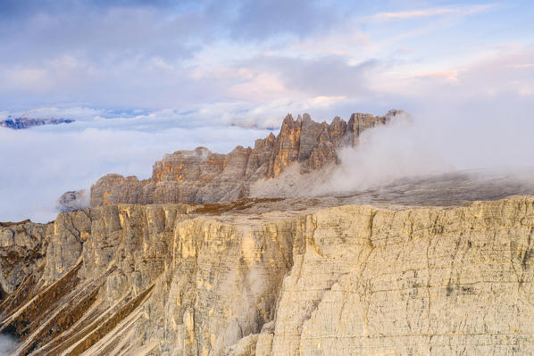 Autumn mist on the majestic rocks of Cima Ambrizzola at sunset, aerial view, Giau Pass, Dolomites, Belluno province, Veneto, Italy