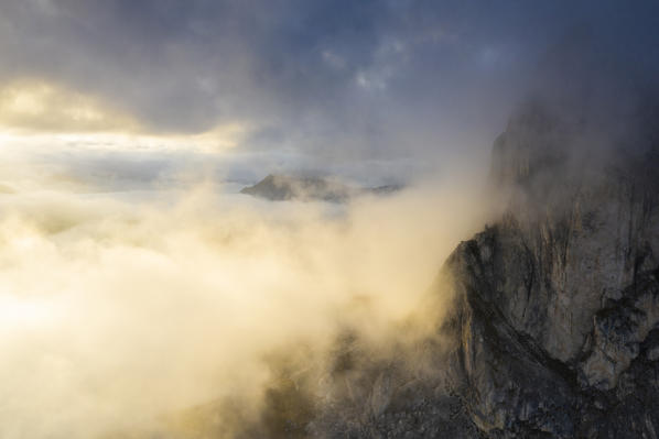 Foggy sky at sunset over Giau Pass and mountains in autumn, aerial view, Dolomites, Belluno province, Veneto, Italy