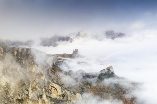 Autumn mist over the larch tree woods surrounding Cinque Torri and Tofane, aerial view, Giau Pass, Dolomites, Belluno, Veneto, Italy