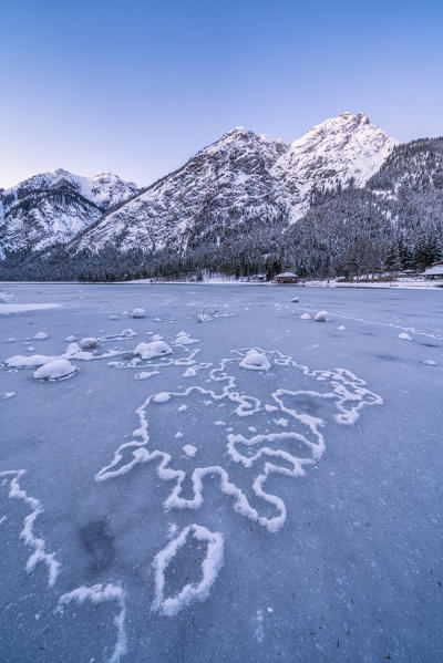 Ice shapes on the frozen surface of Lake Dobbiaco at sunrise, Dobbiaco, Val Pusteria, Dolomites, Bolzano, South Tyrol, Italy