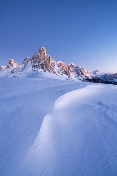 Dusk lights on Ra Gusela mountain and snowy slopes, Giau Pass, Dolomites, Belluno province, Veneto, Italy