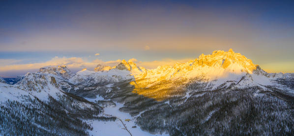 Aerial panoramic of Tre Cime di Lavaredo and Cadini di Misurina covered with snow at sunset, Misurina, Dolomites, Veneto, Italy