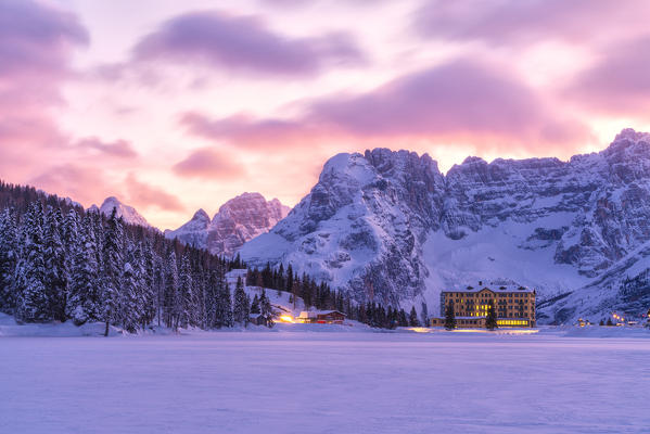 Pink sky at sunset due to foehn (Favonio) wind over Misurina and Sorapis covered with snow, Dolomites, Belluno, Veneto, Italy